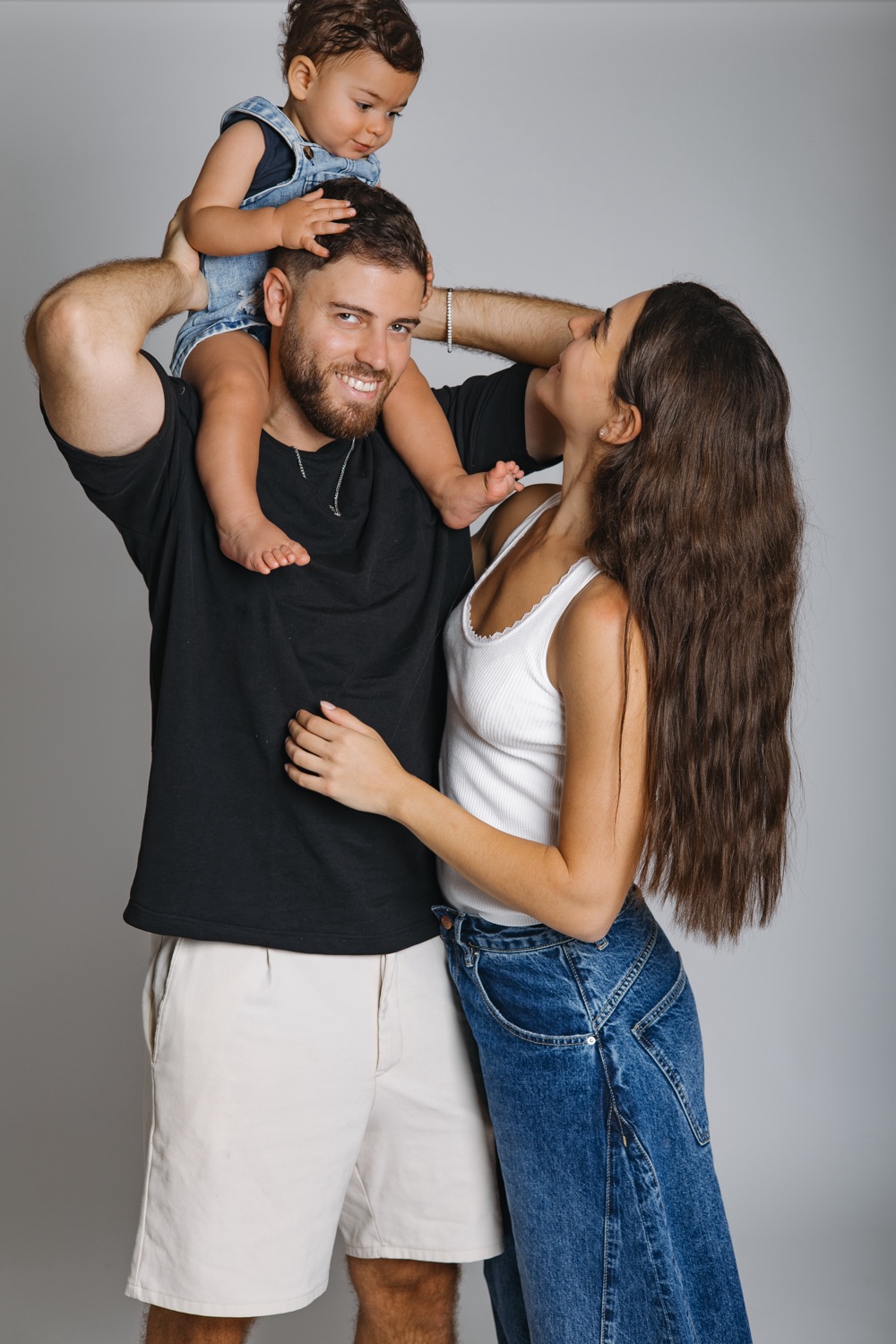 ילד על הכתפיים של אבא, אמא צוחקת לידם